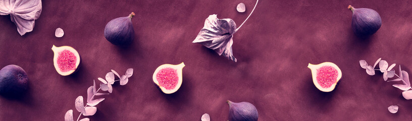 Panoramic banner Autumntime background with fresh halved fig fruits. Dry eucalyptus and cala lily...
