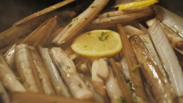 Razor clams seafood grilled on market, grill Spanish Navajas, traditional food in Spain, Catalonia, Barcelona.