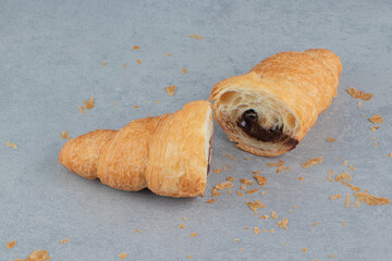 Sliced chocolate croissant on the blue background