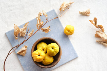 Colorful Autumn pattern with yellow quince fruits on blue ceramic tile. Seasonal Fall still life...