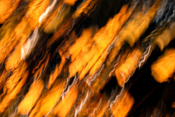 Abstract autumnal backgrounds with blurred yellow foliage. Long exposure camera movement.