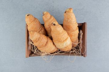 Fototapeta na wymiar Croissants in wooden bowl on the marble background