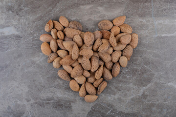 A picture of a heart made of almonds , on the marble background