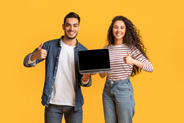 Smiling Arab Couple Holding Laptop With Black Screen And Showing Thumbs Up