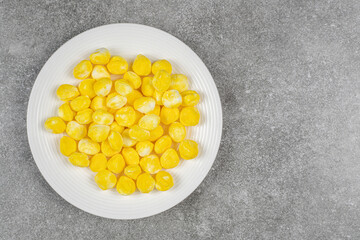 Yellow sweet candies in a white plate