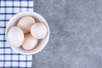 Fresh white chicken eggs on a white plate