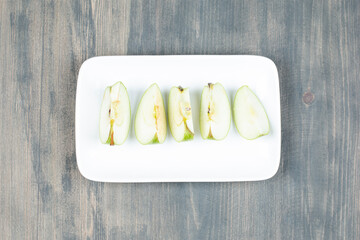 Green apple sliced isolated on a white plate