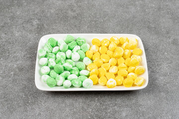 Yellow and green sweet candies in a white plate