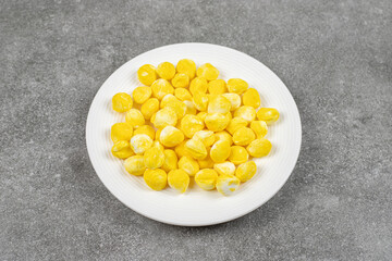 Yellow sweet candies in a white plate