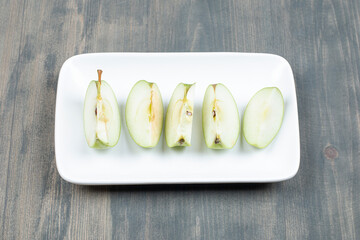 Green apple sliced isolated on a white plate