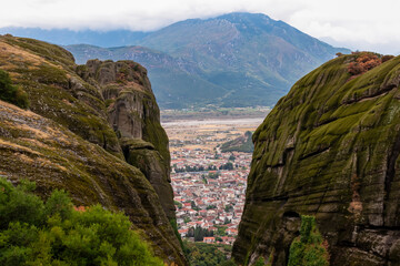 Scenic aerial view of tourist village of Kalambaka, Thessaly, Greece, Europe, Pindus mountains. Dramatic rock complex of Meteora seen from Holy Trinity Monastery build on moss overgrown rock formation