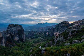 Main observation deck of Meteora with panoramic view of smooth rock pinnacles formation and Holy Eastern Orthodox Monasteries, Kalambaka, Meteora, Thessaly, Greece, Europe. Dramatic evening landscape