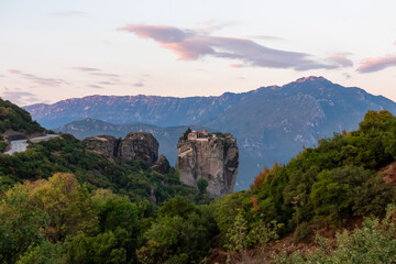 Naklejka premium Scenic sunset view of Holy Trinity Monastery (Agia Triada, Ayias Triadhos, Ayia Triada), Kalambaka, Meteora, Thessaly, Greece, Europe. Athamanika, Tzoumerka mountains. Orthodox church rock formation