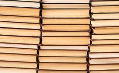 Pile towers of many books, old literature heap. Paper textbooks background