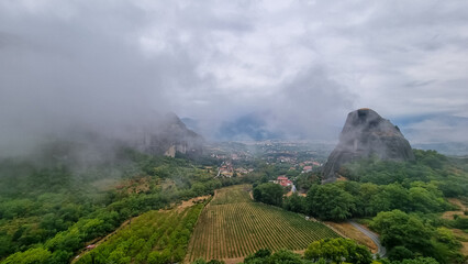 Panoramic view of Holy Orthodox Monastery of Rousanou (St. Barbara), Kalambaka, Meteora, Thessaly, Greece, Europe. Unique rock formation are surrounded by mystical fog. Moody dramatic atmosphere