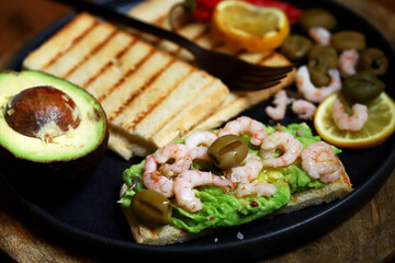 Toast with avocado paste and grilled shrimp.