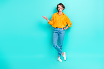 Fototapeta na wymiar Full length photo of cute lady arm direct empty space promo big black friday sale wear trendy outfit isolated on cyan color background