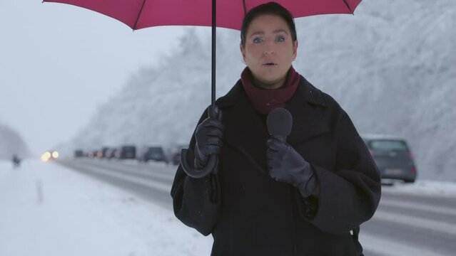  Reporting on Winter Road Conditions - A journalist is reporting on road and traffic conditions in a busy recreation area
