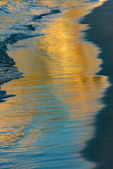 Wave on the shore of the beach with reflections