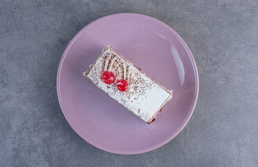 Piece of delicious cake on purple plate