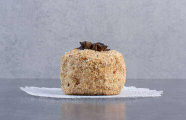 Piece of homemade cake decorated with clove on marble surface