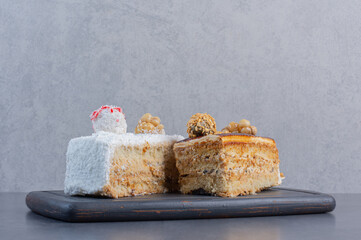 Two kinds of delicious cakes on wooden board