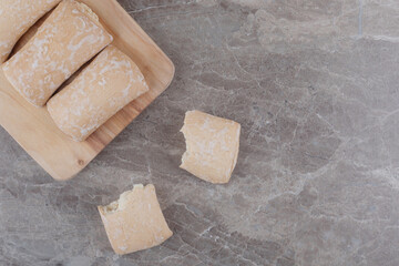 Cookies with filling bundled on a board on marble background