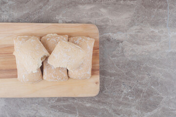 Cookies with filling bundled on a board on marble background