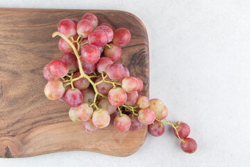 Cluster of fresh grapes on wooden board
