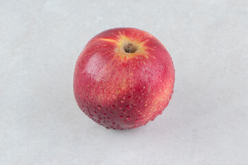 Single red apple on stone background