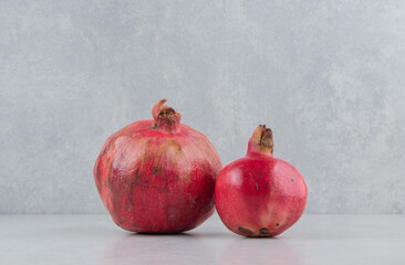 Two fresh pomegranates on stone background