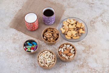 Sweets and crackers with cups of tea and nuts