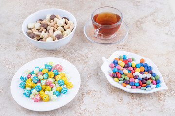 A cup of hot tea with colorful candies