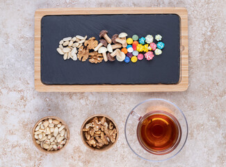A cup of hot tea with colorful candies