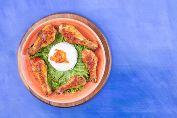 A wooden board of grilled chicken legs meat with boiled egg