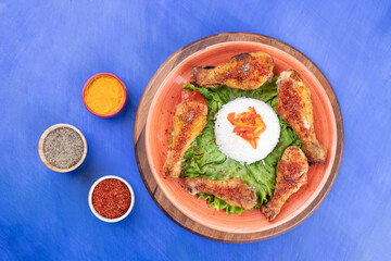 A wooden board of grilled chicken legs meat with boiled egg