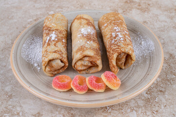 Homemade crepes with sugar powder and sweet marmalades