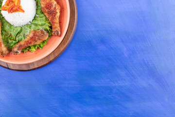 A wooden board of grilled chicken legs meat with boiled egg