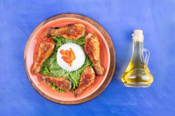 Grilled chicken legs meat with boiled egg and a glass bottle of oil