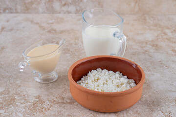 A clay bowl full of delicious cottage cheese and a glass cup of milk