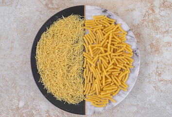 Various types of uncooked macaroni on a beautiful plate