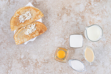 Roll pancakes with cottage cheese and a wooden spoon
