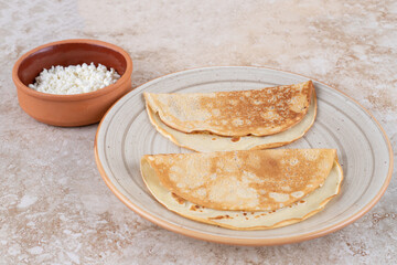 A plate of roll pancakes with cottage cheese