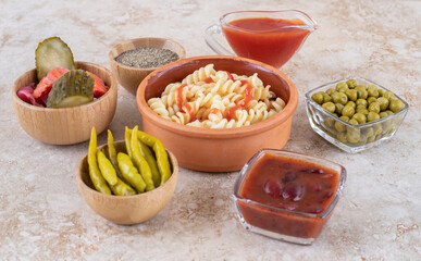A clay bowl of delicious pasta with various vegetables