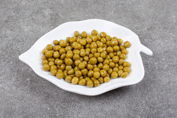 Pile of canned peas on white plate