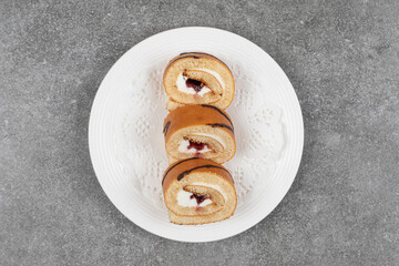 Slices of sweet roll cake on white plate