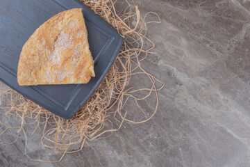 A slice of feseli flatbread on a board on marble background