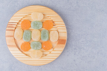 Marmelades neatly arranged on a wooden platter on marble background