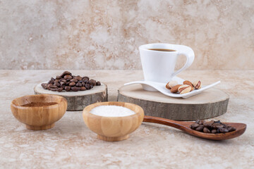 An arrangement with coffee, sugar and nuts on marble background