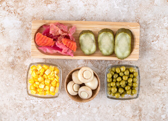 Fresh and pickled vegetables bundled together on marble background